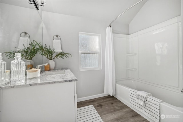 bathroom featuring vanity, vaulted ceiling, shower / bath combo, and wood-type flooring