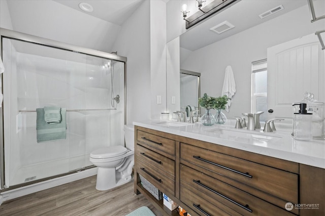 bathroom featuring hardwood / wood-style floors, toilet, vanity, and walk in shower