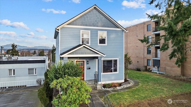 view of front of house with a mountain view and a front lawn