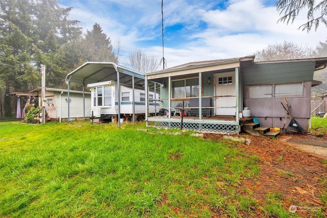 rear view of property featuring a yard and a carport