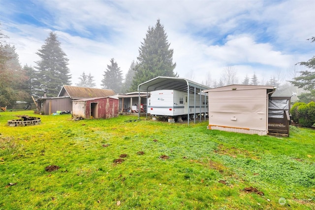 view of yard featuring a storage unit and a carport