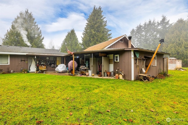 rear view of property with a patio and a lawn