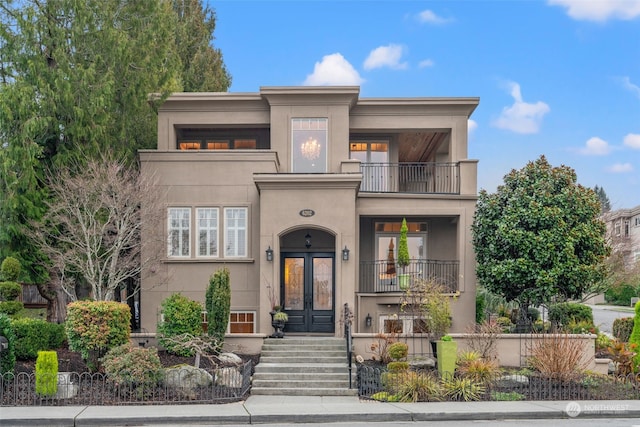 view of front of home with french doors and a balcony