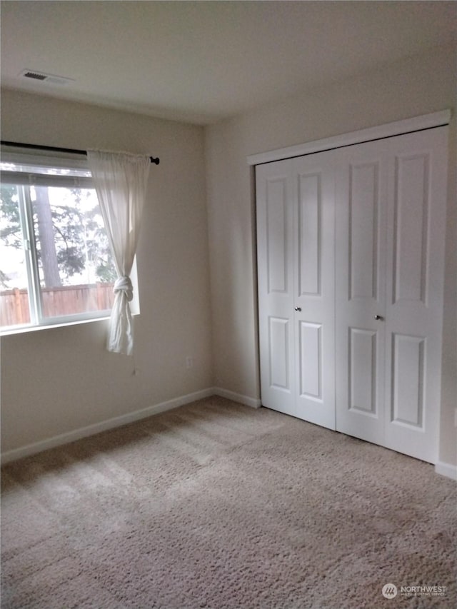 unfurnished bedroom with a closet and carpet