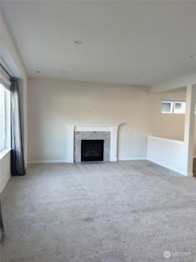 unfurnished living room featuring carpet floors and a fireplace