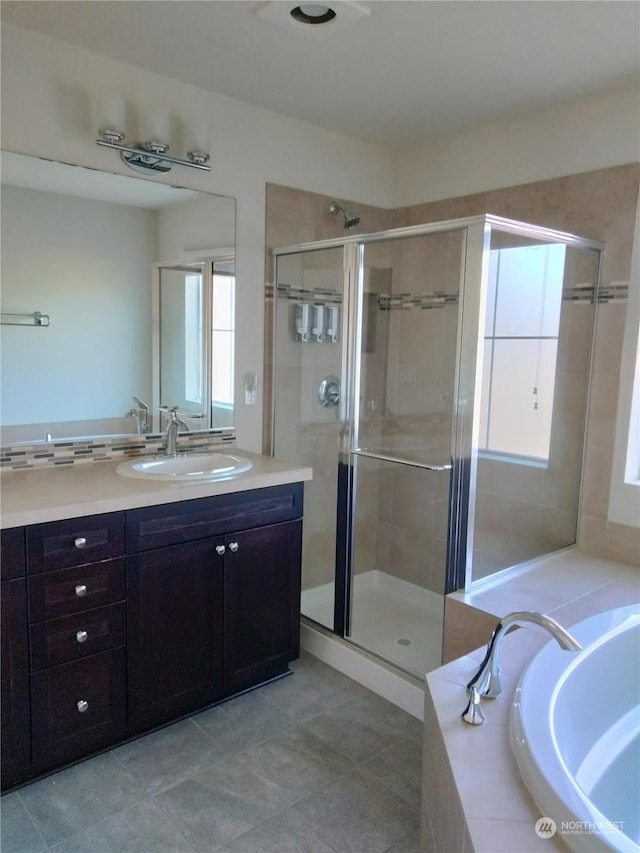 bathroom featuring tile patterned flooring, shower with separate bathtub, and vanity