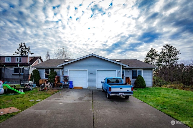 ranch-style house featuring a garage, a front lawn, and a trampoline