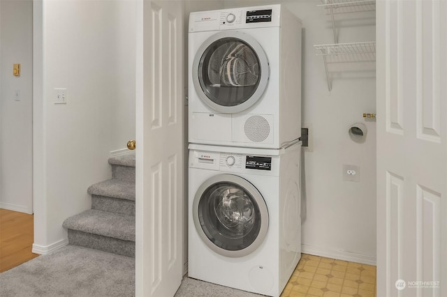 clothes washing area featuring stacked washing maching and dryer