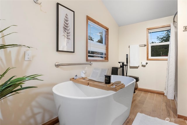 bathroom featuring a bath and vaulted ceiling