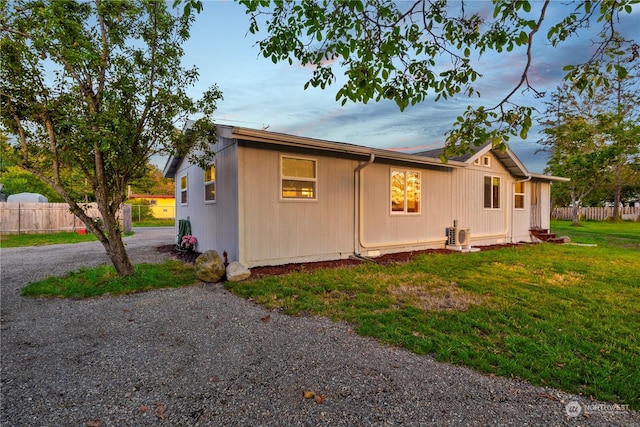 property exterior at dusk with a lawn