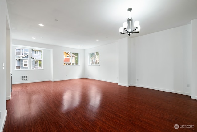 unfurnished room with dark hardwood / wood-style flooring and an inviting chandelier