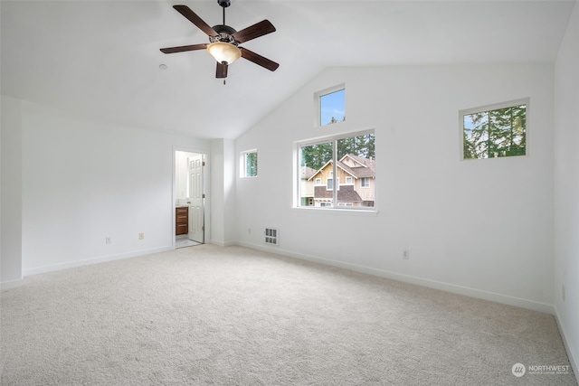 carpeted empty room with ceiling fan, a wealth of natural light, and lofted ceiling