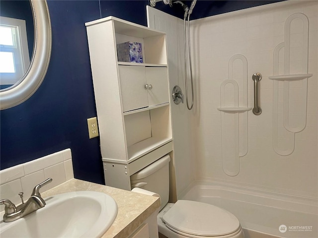 bathroom with toilet, a shower, and vanity