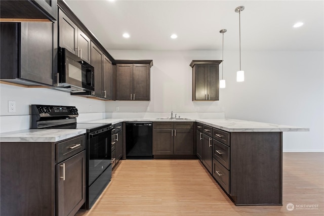 kitchen featuring pendant lighting, black appliances, sink, kitchen peninsula, and light hardwood / wood-style flooring