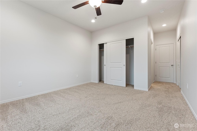 unfurnished bedroom with ceiling fan, a closet, and light carpet