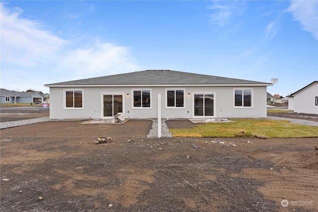 back of property with a yard and a patio