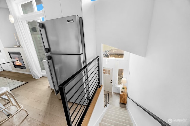 stairs with a towering ceiling and wood-type flooring