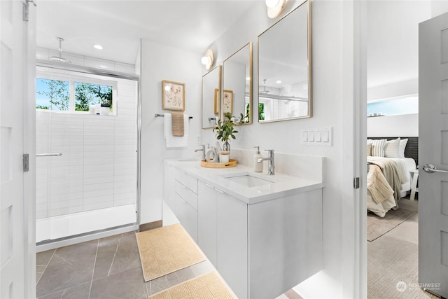 bathroom with tile patterned flooring, walk in shower, and vanity