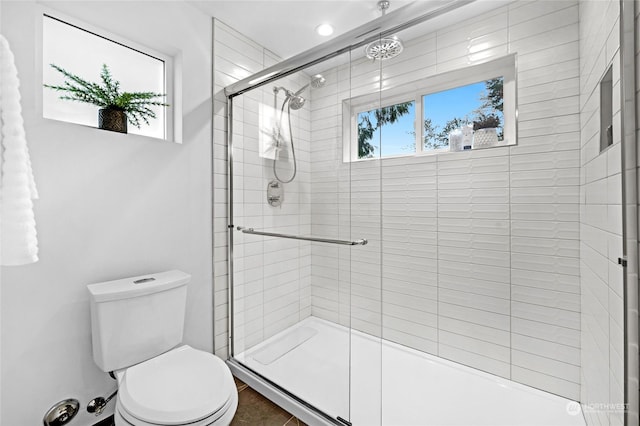 bathroom featuring walk in shower and toilet