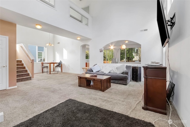 carpeted living room featuring a towering ceiling