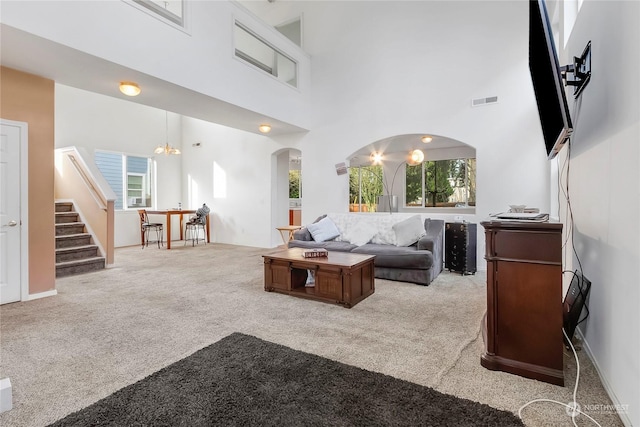 carpeted living room with a high ceiling