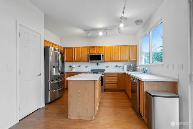 kitchen featuring sink, stainless steel appliances, a center island, and light hardwood / wood-style floors