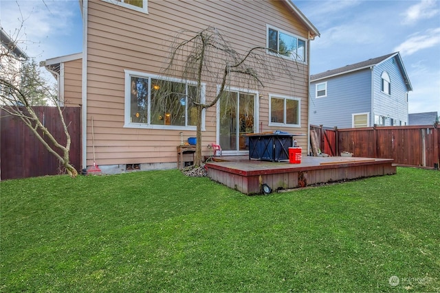 rear view of house with a yard and a deck