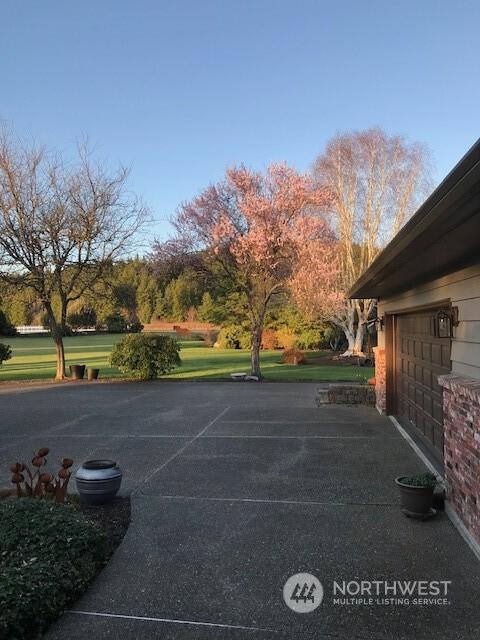 view of vehicle parking with a lawn