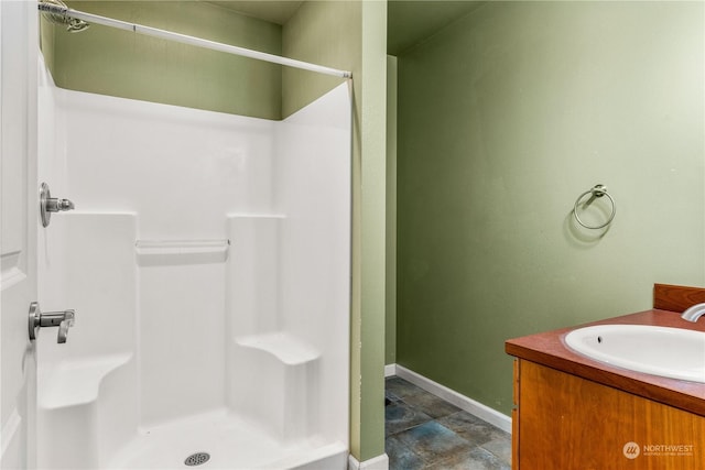 bathroom featuring walk in shower and vanity