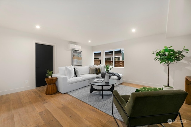 living room featuring an AC wall unit and light hardwood / wood-style flooring