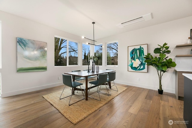 dining space featuring an inviting chandelier and light hardwood / wood-style flooring