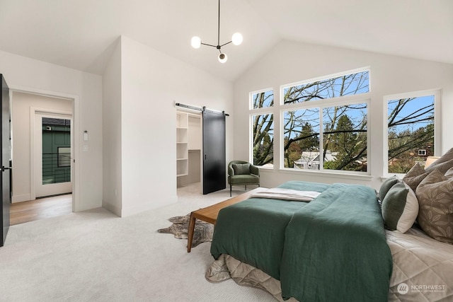 carpeted bedroom featuring lofted ceiling, a barn door, a walk in closet, and a notable chandelier