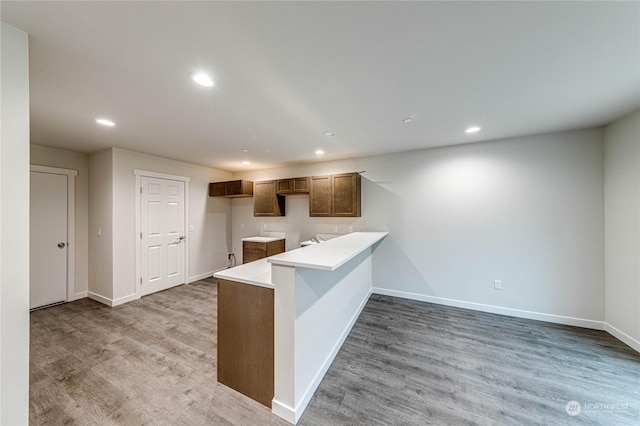 kitchen with kitchen peninsula and light hardwood / wood-style flooring