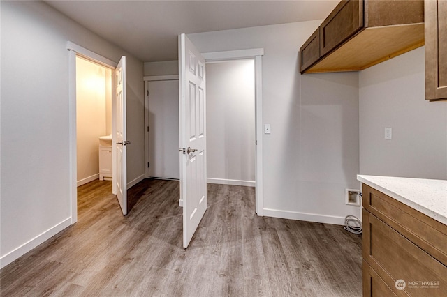 laundry area with cabinets, hookup for a washing machine, and light wood-type flooring