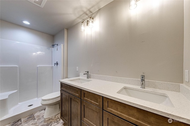 bathroom with vanity, toilet, and a shower