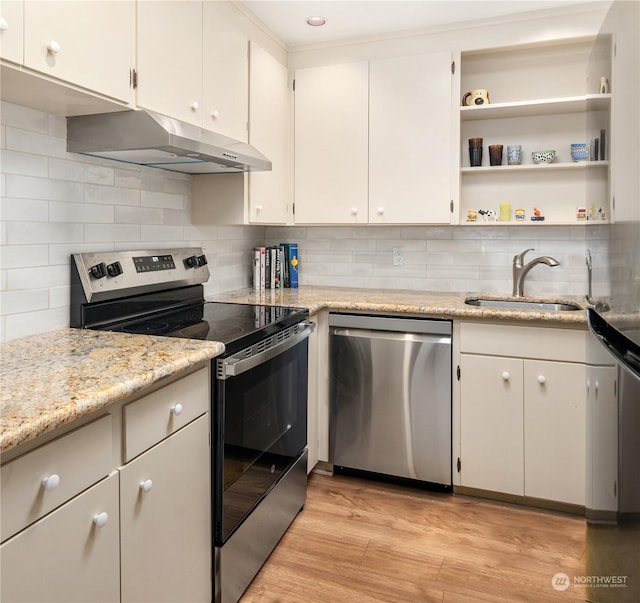 kitchen featuring light stone countertops, stainless steel appliances, decorative backsplash, sink, and light hardwood / wood-style flooring