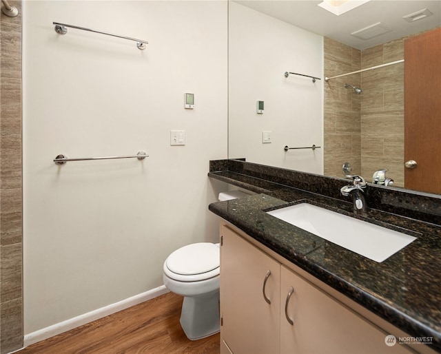 bathroom with toilet, hardwood / wood-style flooring, and vanity