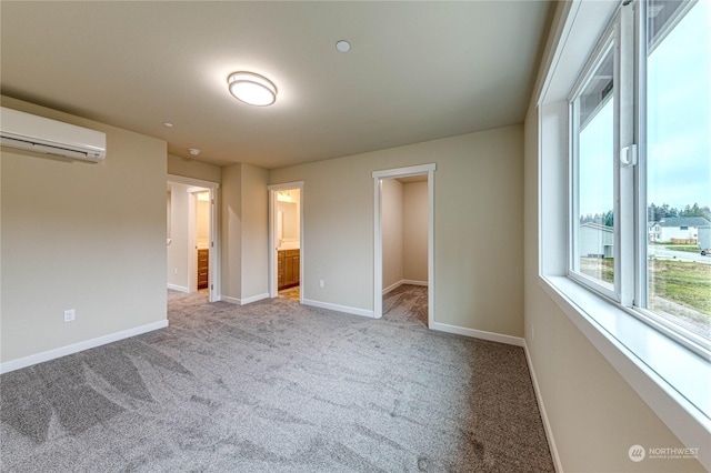 unfurnished bedroom with ensuite bathroom, light colored carpet, a wall mounted air conditioner, a spacious closet, and a closet