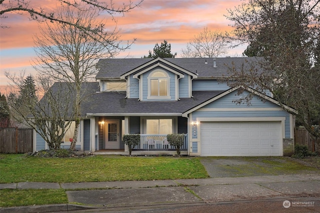 view of front facade featuring a garage, covered porch, and a lawn