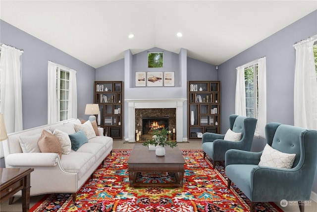 living room with a premium fireplace and vaulted ceiling