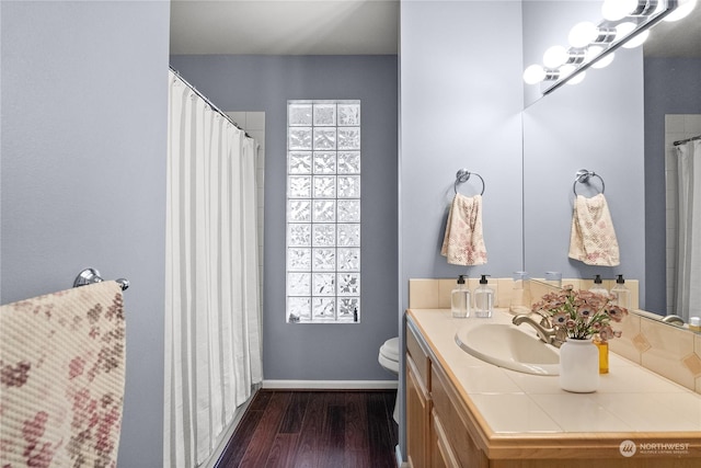 bathroom featuring toilet, vanity, and wood-type flooring