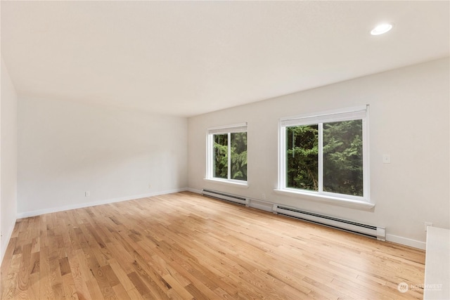 spare room with a baseboard radiator and light wood-type flooring