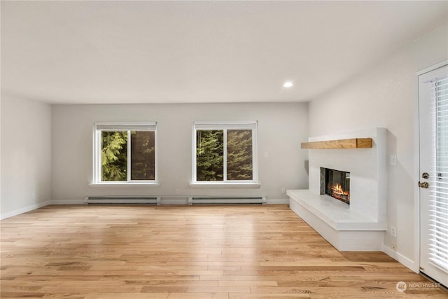 unfurnished living room with light hardwood / wood-style flooring and a baseboard radiator