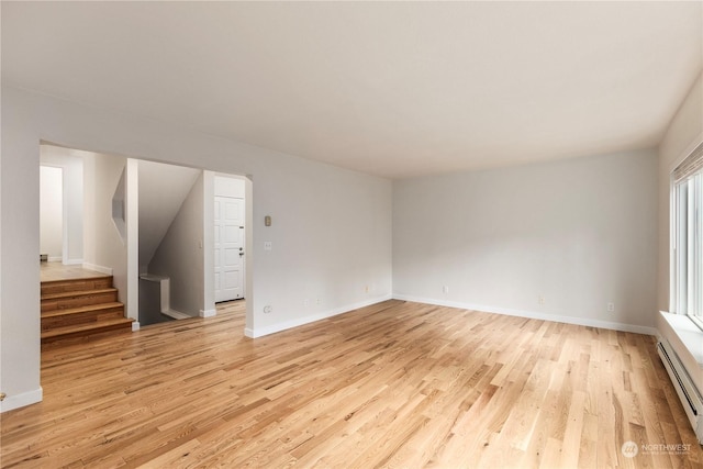 empty room featuring light hardwood / wood-style floors and a baseboard radiator