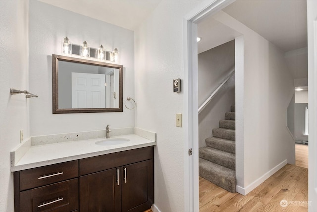 bathroom with baseboard heating, wood-type flooring, and vanity