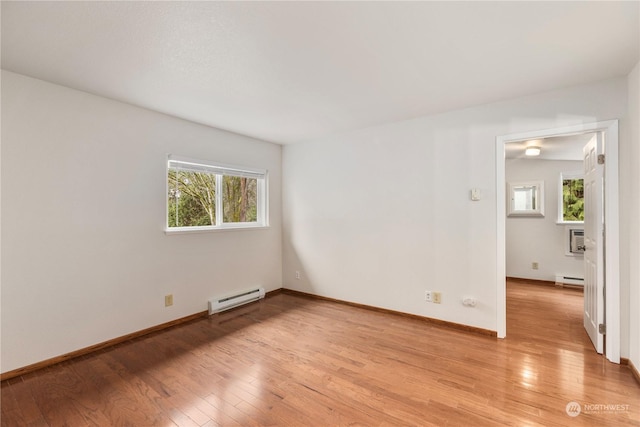 spare room with baseboard heating and light wood-type flooring