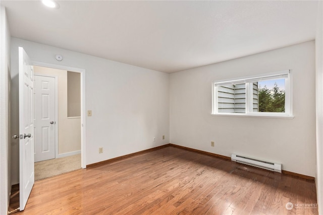 spare room featuring light hardwood / wood-style floors and a baseboard heating unit