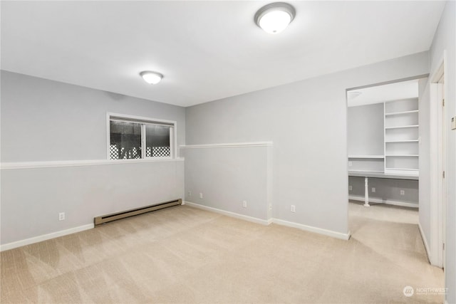 carpeted spare room featuring baseboard heating