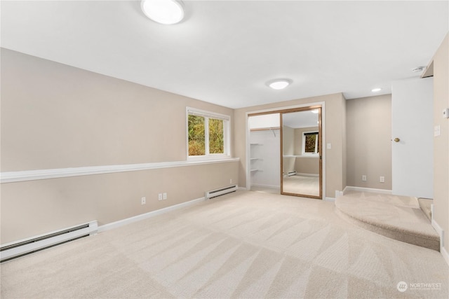 unfurnished bedroom with light colored carpet, a closet, and a baseboard heating unit