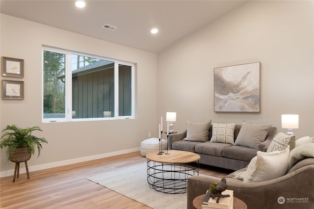 living room with light wood-type flooring and lofted ceiling